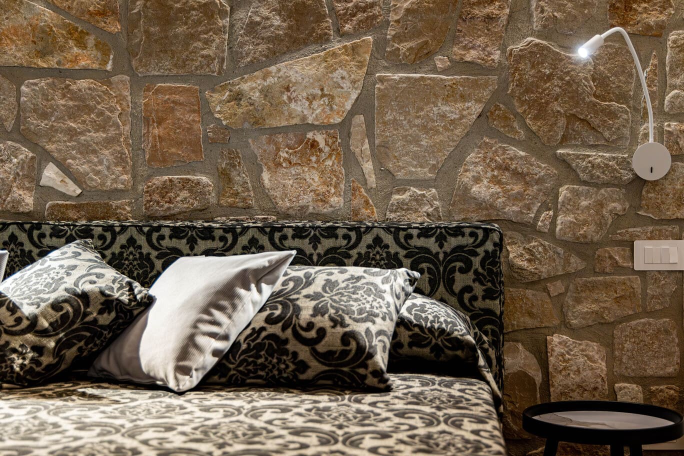 Camera perla, letto con parete in pietra